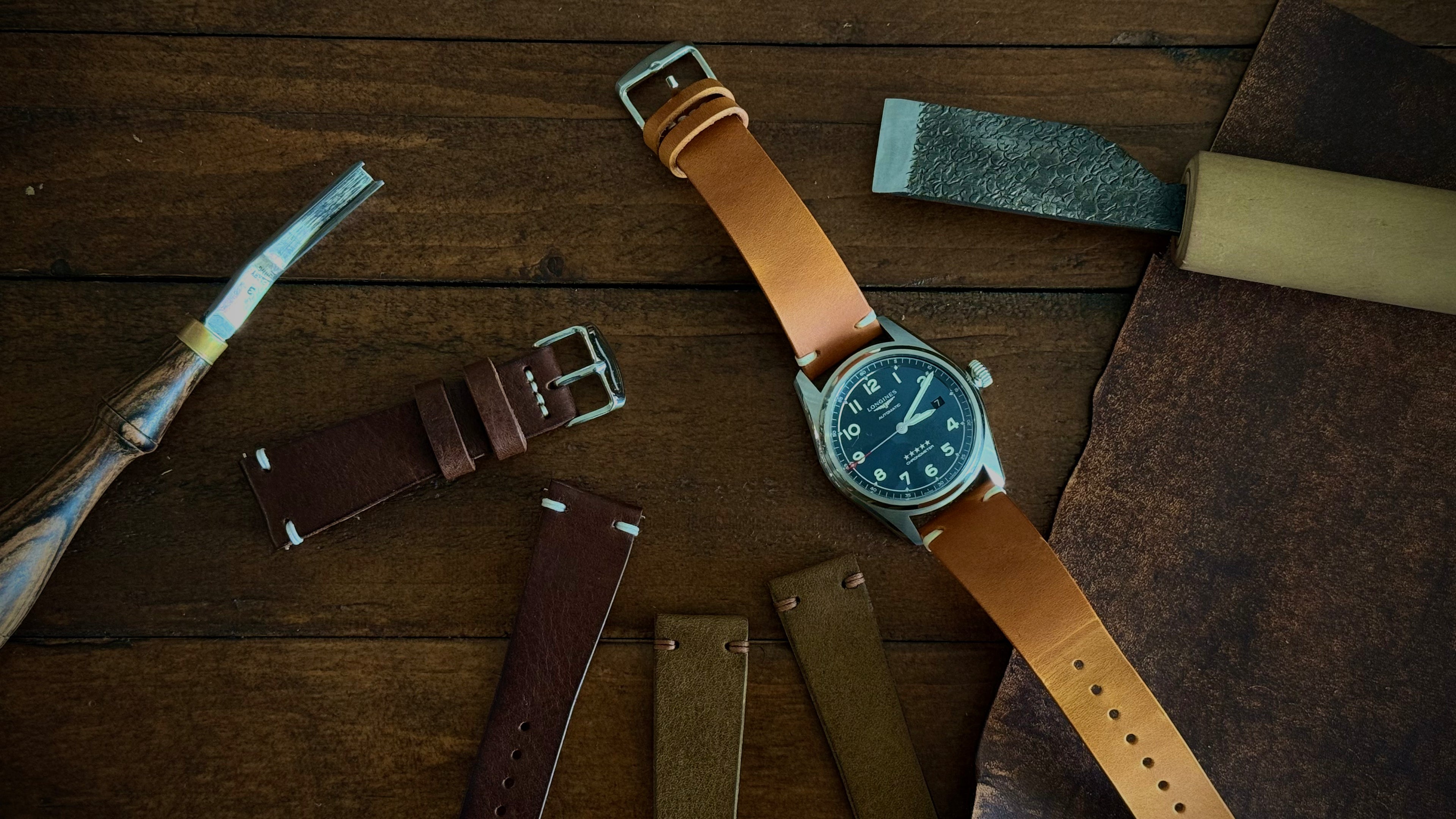 Watch with multiple leather straps on a wooden surface